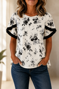 Blusa blanca de manga corta con estampado floral negro